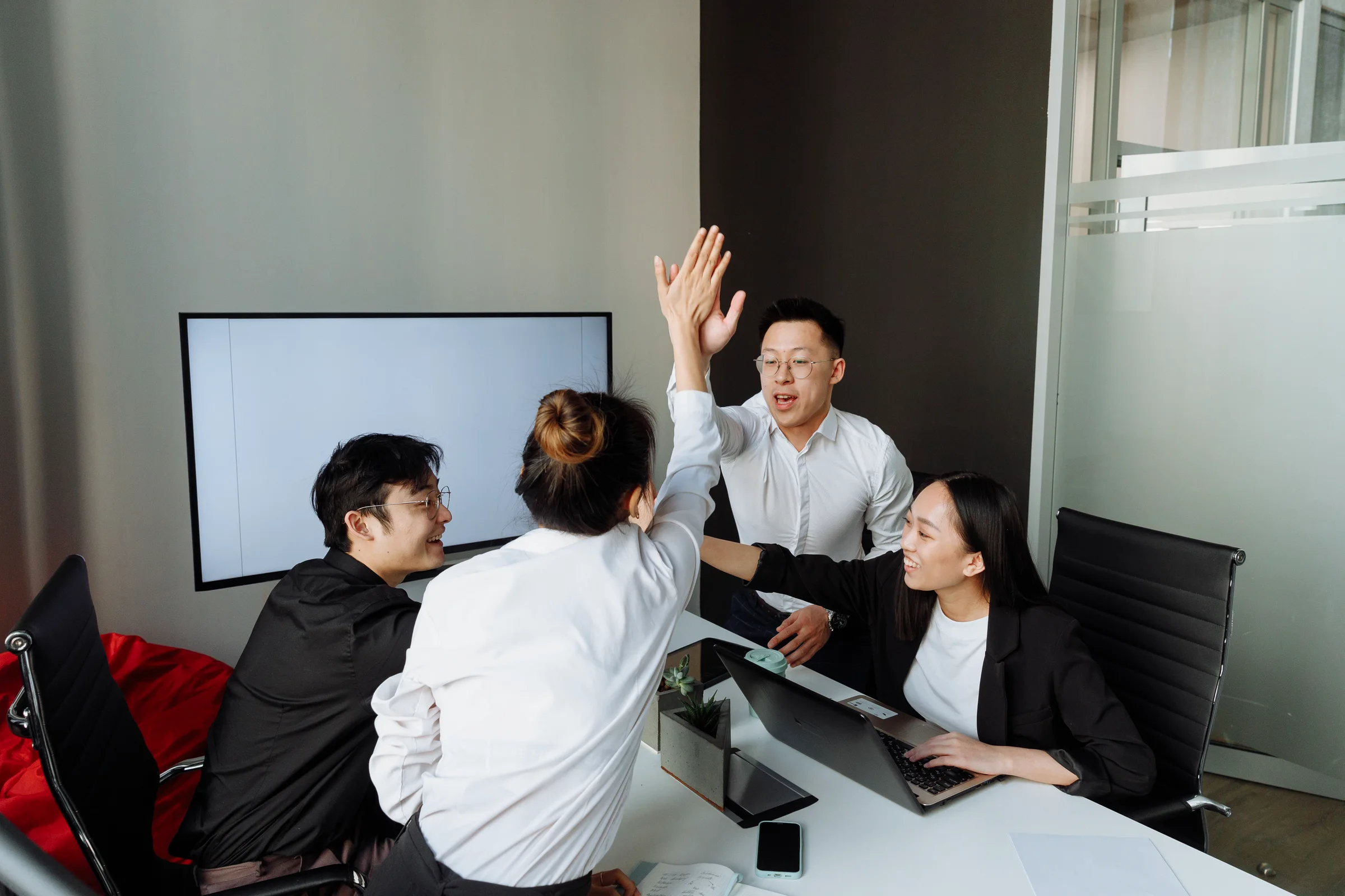 Fincerty finance exam candidates celebrating corporate study success in an office